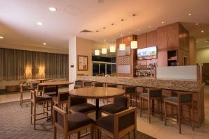 瓜达拉哈拉Hampton by Hilton Guadalajara Expo的一间带桌椅的餐厅和一间酒吧