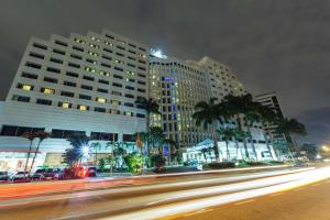 瓜亚基尔科隆瓜亚基尔希尔顿酒店的一条城市街道,晚上有建筑和棕榈树