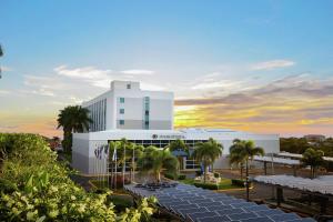 马那瓜Hilton DoubleTree by Hilton Managua的一座白色的大建筑,前面有棕榈树