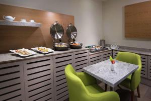 蒙特雷蒙特雷机场希尔顿花园酒店的一间带桌子和绿色椅子的用餐室