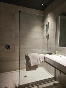 布兰维尔Grand Hotel TiMES Blainville-Mirabel的带淋浴和盥洗盆的浴室