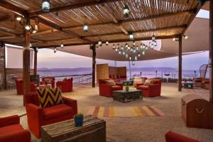 帕拉卡斯The Legend Paracas Resort的客厅配有红色家具,享有海景