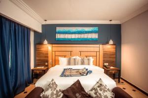 林贝Marcsons Hotels and Resorts的卧室配有白色大床和蓝色的墙壁