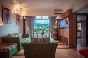 林贝Marcsons Hotels and Resorts的客厅配有沙发和美景窗户。