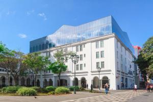 圣何塞哥斯达黎加格兰希尔顿Curio Collection酒店的一座白色的大建筑,拥有玻璃幕墙