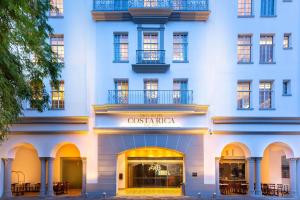 圣何塞哥斯达黎加格兰希尔顿Curio Collection酒店的带有精品店标志的白色建筑