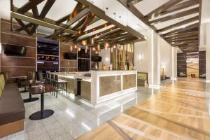 圣何塞希尔顿花园酒店 －圣何塞拉萨瓦纳，哥斯达黎加的餐厅内的酒吧设有木地板和天花板