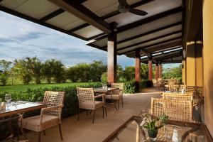 利比里亚Hilton Garden Inn Guanacaste Airport的享有美景的带桌椅的庭院。