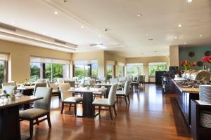 利比里亚Hilton Garden Inn Guanacaste Airport的用餐室设有桌椅和窗户。