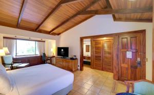 圣何塞Hilton Cariari DoubleTree San Jose - Costa Rica的一间卧室配有一张床和一台电视。