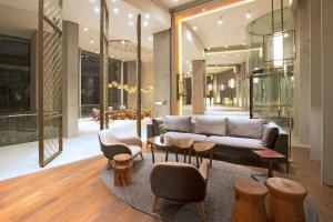圣地亚哥DoubleTree by Hilton Santiago Kennedy, Chile的客厅配有沙发和桌椅