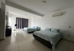 图斯特拉古铁雷斯Casa moderna climatizada en Tuxtla Gutiérrez的一间卧室配有两张床和电视。