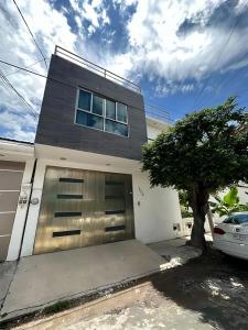 图斯特拉古铁雷斯Casa moderna climatizada en Tuxtla Gutiérrez的前面有树的车库