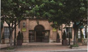 波哥大波哥大-罗萨莱斯希尔顿合博套房酒店的前面有门和树木的砖砌建筑