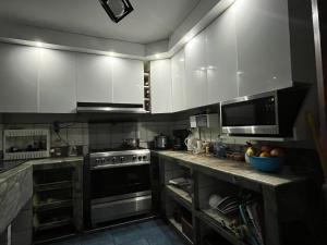 巴兰卡Alójate en una Casa familiar的厨房配有白色橱柜和炉灶烤箱。