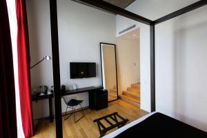 布宜诺斯艾利斯安塞尔莫布宜诺斯艾利斯希尔顿Curio Collection酒店的客房设有床、电视和镜子