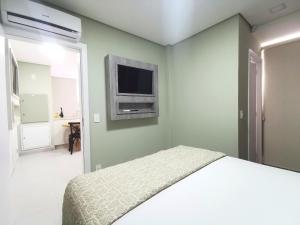 伊瓜苏Click Apê Prime Foz的卧室配有一张床,墙上配有电视。