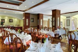 马那瓜马那瓜公主希尔顿酒店的一间设有白色桌椅的用餐室