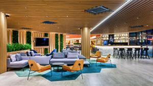 瓜鲁柳斯Hampton by Hilton Guarulhos Airport的带沙发和椅子的大堂以及酒吧