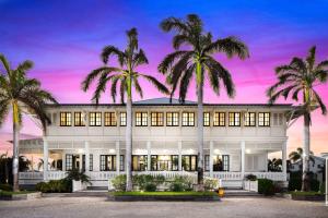 圣佩德罗Mahogany Bay Resort and Beach Club, Curio Collection的一座白色的大建筑,前面有棕榈树