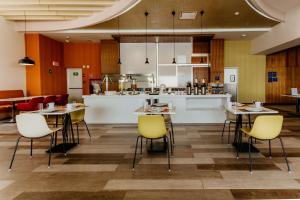 锡劳Hilton Garden Inn Silao Aeropuerto Bajio的一间带桌椅的餐厅和一间厨房