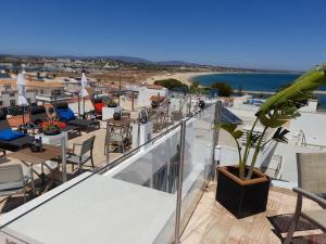 拉戈斯Casa Paula Apartments的设有带桌椅的阳台,享有海滩美景