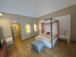 比谢列Palazzo Bonomi的一间卧室配有四柱床和电视。
