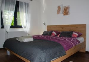 圣马丁娜穆里Kraljeva hiža - Apartmani i sobe Kralj的一间卧室配有一张带紫色床单的大床和窗户。