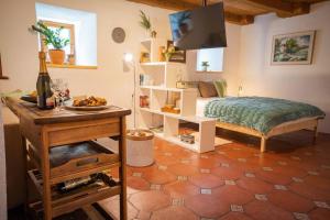 奥斯尼卡Studio Apartment Pr' Mirotu的一间卧室配有一张床和一张桌子及一瓶葡萄酒