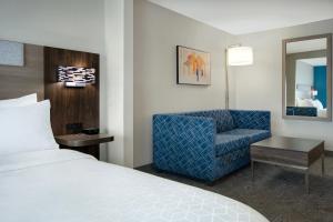 玛丽埃塔市 亚特兰大西北玛丽埃塔智选假日酒店的酒店客房,配有一张床和一张蓝色椅子