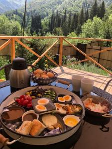 Kamenskoye PlatoEywa House的一张桌子,早餐包括鸡蛋和面包