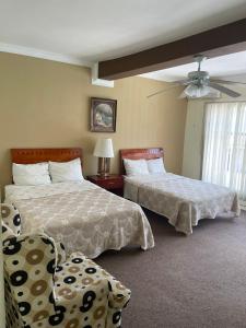 杜兰戈吕康里尔套房酒店的一间卧室配有两张床和吊扇