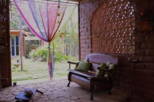 圣若热岛Espaço Shanti - Chalés的带沙发和窗户的客厅