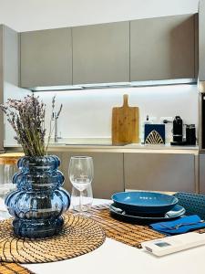 米兰Tarra Luxury Suite的一张桌子,上面有蓝色玻璃花瓶