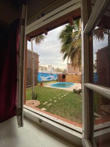 门多萨Open House Hostel的从房子的窗户可欣赏到游泳池的景色