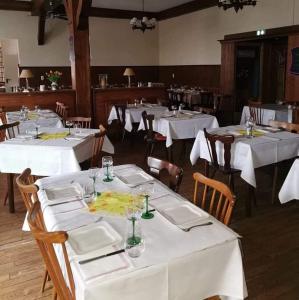 SessenheimHôtel restaurant à la croix d'or的一间设有白色桌椅的用餐室