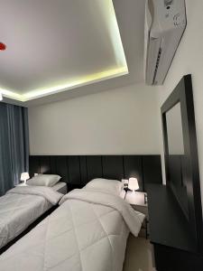 安曼Modern 2bedroom For Rent Abdoun2的配有两张床铺的客房配有两盏灯和镜子