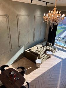 克莱佩达ALL - Amberstone Lux Loft的客厅配有吊灯、沙发和桌子