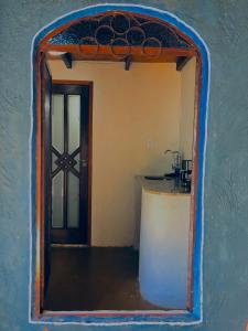 圣若热岛Espaço Shanti - Chalés的厨房的镜子反射,有门