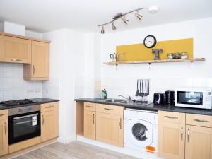 埃普瑟姆Stylish 2 bedroom apartment in the heart of Epsom town centre的厨房配有洗衣机和微波炉。