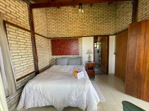 巴西利亚Guest House Jardim Botânico Brasília的卧室配有砖墙内的床铺