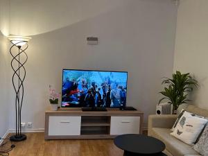 奥勒松Apartment in Ålesund city center (Storgata)的客厅配有餐桌上的平面电视