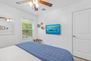 GroveCozy Cottage • King Bed • Grove • Kayaks • Boat Parking的一间卧室配有蓝色的床和吊扇
