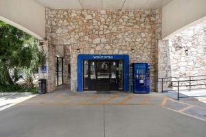 圣安东尼奥圣安东尼奥西北6号汽车旅馆 - 医疗中心的通往大楼的蓝色入口,带电话亭