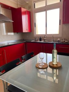 拉克鲁斯Coqueto apartamento familiar的厨房配有带一瓶酒和一杯葡萄酒的桌子
