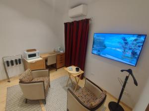 贝尔格莱德Balkanska Four Seasons Suites的客厅配有椅子和墙上的电视