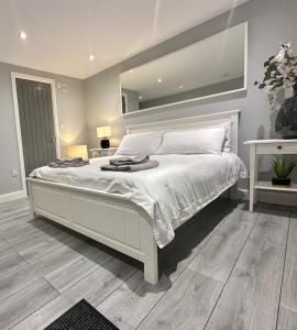 卢顿Modern Luxury Private Detached 1 Double Bedroom Studio Apartment - Super Fast Wifi的卧室配有一张大白床和大镜子
