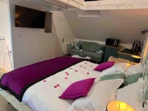 皮埃尔丰Le Cocon des Remparts-Logis Élégant à Pierrefonds的一间卧室配有一张带紫色枕头的大床