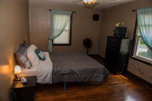 路易斯威尔Schillhaus的一间卧室配有带枕头的床铺和电视。