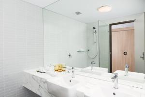 悉尼帕拉马塔莱吉斯酒店的一间带两个盥洗盆和大镜子的浴室